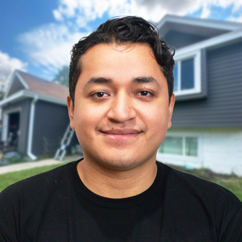 A smiling person in front of a house showcasing roofing work.