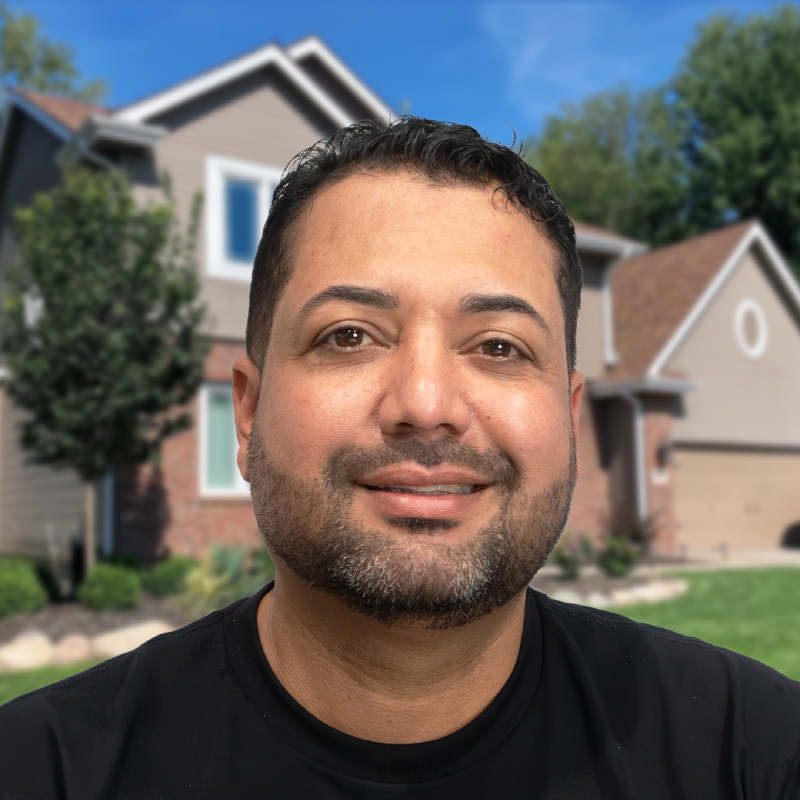 Man standing in front of a suburban home with a well-maintained roof.