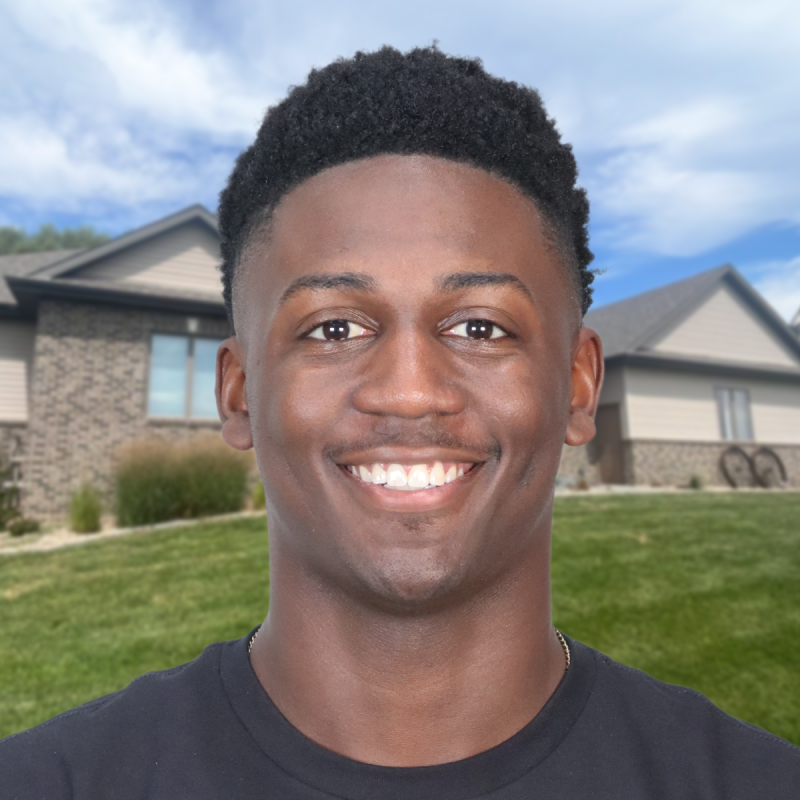 Smiling man standing in front of a suburban house in Omaha.