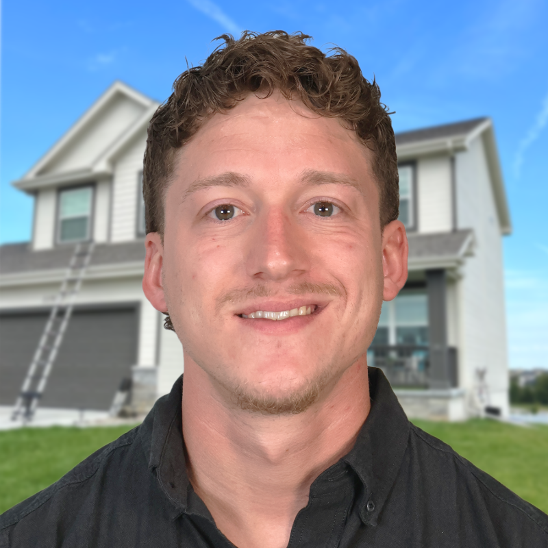 Omaha roofing professional in front of a suburban house with ladder in view.